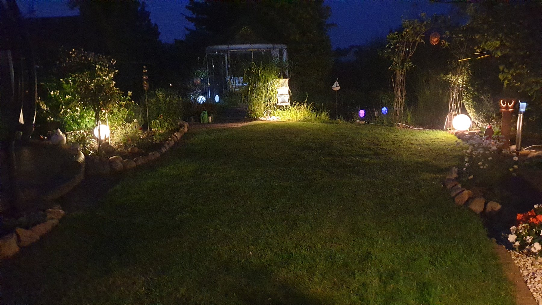Stimmungsvoll beleuchteter Garten bei Nacht