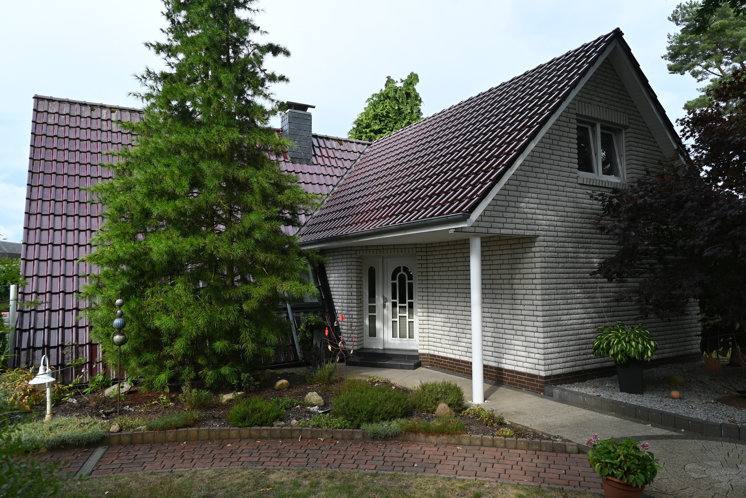 Aktuelle Hausansicht mit gepflegtem Vorgarten