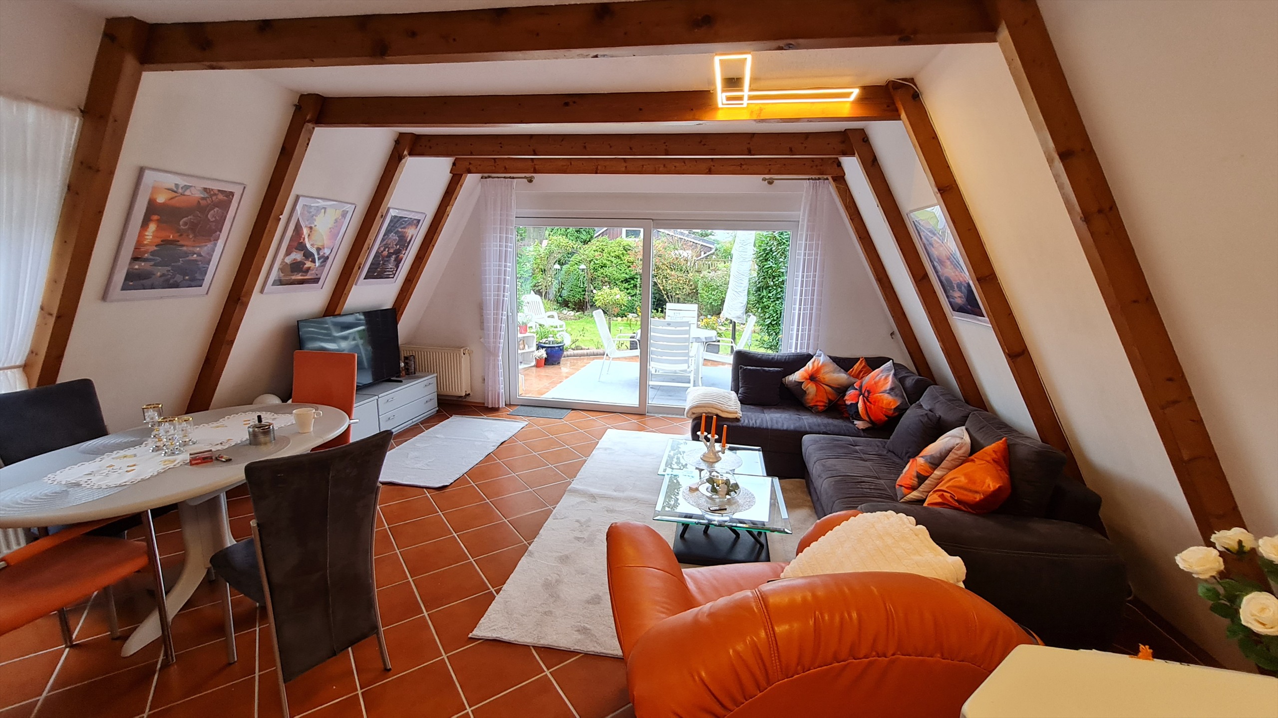 Wohnzimmer mit Sofa und direktem Gartenzugang